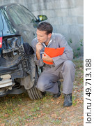 Mechanic assessing damage to rear of car. Стоковое фото, агентство Ingram Publishing / Фотобанк Лори
