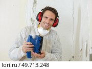 a tradesman holding sander machine. Стоковое фото, агентство Ingram Publishing / Фотобанк Лори