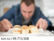 man straightening a plate of canapes. Стоковое фото, агентство Ingram Publishing / Фотобанк Лори