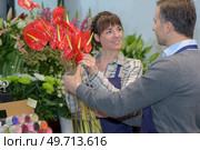 Male and female florists holding Anthurium. Стоковое фото, агентство Ingram Publishing / Фотобанк Лори