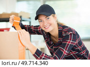 young woman taping up a cardboard boxes. Стоковое фото, агентство Ingram Publishing / Фотобанк Лори