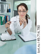 female optician offering glasses frames to client. Стоковое фото, агентство Ingram Publishing / Фотобанк Лори