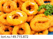Baked breaded calamari rings served with lime. Food background.. Deep fried squid rings, close up. Стоковое фото, агентство Ingram Publishing / Фотобанк Лори