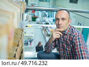 portrait of worker in front of racling. Стоковое фото, агентство Ingram Publishing / Фотобанк Лори