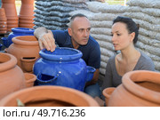 male and female potter examining a pot in pottery workshop. Стоковое фото, агентство Ingram Publishing / Фотобанк Лори
