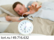 sleepy man reaching to snooze alarm clock. Стоковое фото, агентство Ingram Publishing / Фотобанк Лори