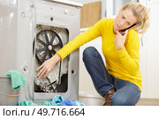 woman mopping up leaking sink on phone to plumber. Стоковое фото, агентство Ingram Publishing / Фотобанк Лори