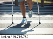 man trying to walk on street with the help crutches. Стоковое фото, агентство Ingram Publishing / Фотобанк Лори