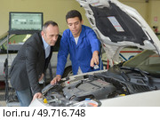 young tinker showing his colleague some problems. Стоковое фото, агентство Ingram Publishing / Фотобанк Лори