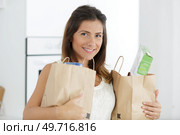 portrait of happy housewife holding grocery shopping checks. Стоковое фото, агентство Ingram Publishing / Фотобанк Лори