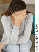sad woman locating on comfortable couch. Стоковое фото, агентство Ingram Publishing / Фотобанк Лори