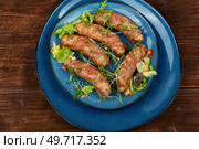Fried sausage on plate on a wooden background. Barbecue bratwurst, top view.. Fried sausage on plate. Стоковое фото, агентство Ingram Publishing / Фотобанк Лори