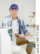 confused man attempting to assemble air conditioning unit. Стоковое фото, агентство Ingram Publishing / Фотобанк Лори