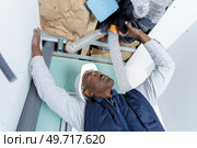 male technician repairing industrial air conditioner indoors. Стоковое фото, агентство Ingram Publishing / Фотобанк Лори
