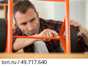 handyman using a spanner to assemble a trolley. Стоковое фото, агентство Ingram Publishing / Фотобанк Лори
