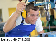 a technician is drilling steel. Стоковое фото, агентство Ingram Publishing / Фотобанк Лори