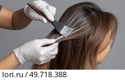 Hair coloring process in a salon with careful application of dye. Процесс окрашивания волос в салоне с тщательным нанесением краски. Стоковое AI-изображение, AI-художник Katsiaryna Repich / Фотобанк Лори