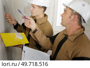 happy builder in hardhat plastering a wall. Стоковое фото, агентство Ingram Publishing / Фотобанк Лори