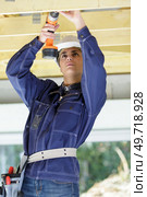 female builder using cordless screwdriver on wooden timbers. Стоковое фото, агентство Ingram Publishing / Фотобанк Лори
