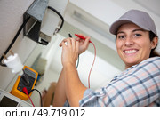 female electrician using multimeter to test an appliance. Стоковое фото, агентство Ingram Publishing / Фотобанк Лори