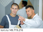 young apprentice painter being given instructions by his mentor. Стоковое фото, агентство Ingram Publishing / Фотобанк Лори
