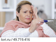 troubled woman measuring her temperature. Стоковое фото, агентство Ingram Publishing / Фотобанк Лори