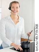 woman receiving call on handfree headset while cooking meal. Стоковое фото, агентство Ingram Publishing / Фотобанк Лори
