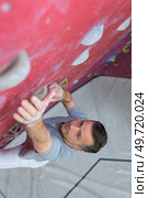 man climber on artificial climbing wall in bouldering gym. Стоковое фото, агентство Ingram Publishing / Фотобанк Лори