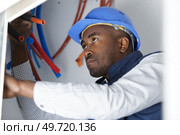 man fixing a leaking pipe under the sink. Стоковое фото, агентство Ingram Publishing / Фотобанк Лори