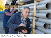worker inspecting the pipes to be deliver. Стоковое фото, агентство Ingram Publishing / Фотобанк Лори
