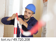 workman setting up exclusion barrier on work site. Стоковое фото, агентство Ingram Publishing / Фотобанк Лори
