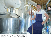 Man wearing apron stood by vat. Стоковое фото, агентство Ingram Publishing / Фотобанк Лори