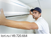 tech guy carefully installing new ac. Стоковое фото, агентство Ingram Publishing / Фотобанк Лори