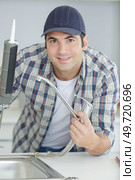worker puts silicone sealant around the sink. Стоковое фото, агентство Ingram Publishing / Фотобанк Лори