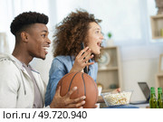 young couple watching basketball match at home. Стоковое фото, агентство Ingram Publishing / Фотобанк Лори