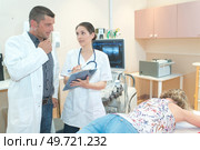 male and female doctor in uniform with clipboard. Стоковое фото, агентство Ingram Publishing / Фотобанк Лори