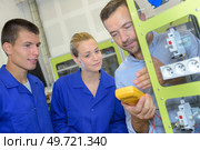 team of workers reading the voltmeter. Стоковое фото, агентство Ingram Publishing / Фотобанк Лори