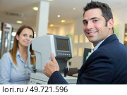 optician doing a scan test to patients eyes. Стоковое фото, агентство Ingram Publishing / Фотобанк Лори