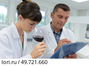 experts in white coats checking wine quality in lab. Стоковое фото, агентство Ingram Publishing / Фотобанк Лори