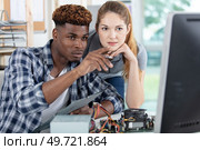 man and woman in computer repair center looking at screen. Стоковое фото, агентство Ingram Publishing / Фотобанк Лори