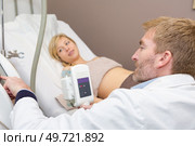 doctor performing obstetric ultrasonography on a pregnant woman. Стоковое фото, агентство Ingram Publishing / Фотобанк Лори