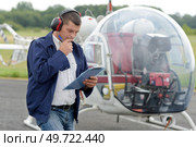 man looking at clipboard stood beside an autogyro. Стоковое фото, агентство Ingram Publishing / Фотобанк Лори