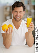 man holding oranges and glass of orange juice. Стоковое фото, агентство Ingram Publishing / Фотобанк Лори