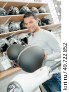 Man holding two crash helmets. Стоковое фото, агентство Ingram Publishing / Фотобанк Лори