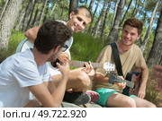 young hippie people relaxing in the forest outdoors. Стоковое фото, агентство Ingram Publishing / Фотобанк Лори