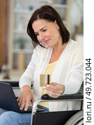 nice senior woman in wheelchair typing card number on laptop. Стоковое фото, агентство Ingram Publishing / Фотобанк Лори