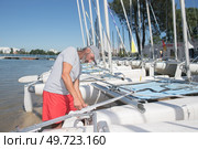 attractive sailor rigging hobbie-cat before sailing course. Стоковое фото, агентство Ingram Publishing / Фотобанк Лори