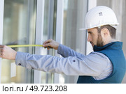 man measuring window prior to installation of roller shutter outdoors. Стоковое фото, агентство Ingram Publishing / Фотобанк Лори