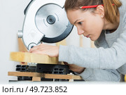 Female carpenter aligning wood to circular saw. Стоковое фото, агентство Ingram Publishing / Фотобанк Лори