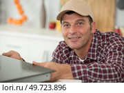man installing an electronic hob. Стоковое фото, агентство Ingram Publishing / Фотобанк Лори